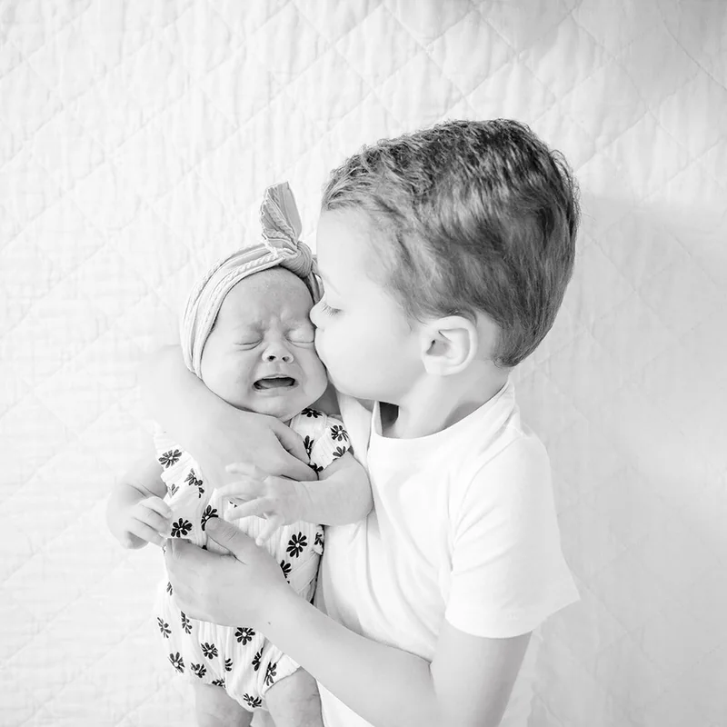 Older sibling meeting a newborn during a Central Florida newborn session