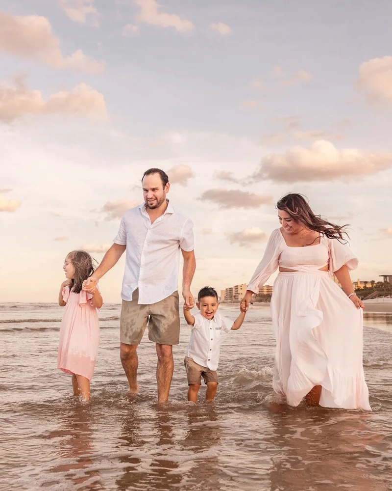 Family walking along the shoreline at New Smyrna Beach