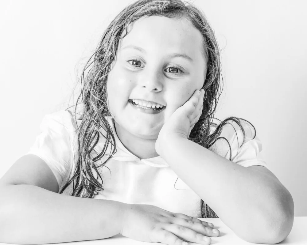 Siblings photographed together in a clean studio portrait